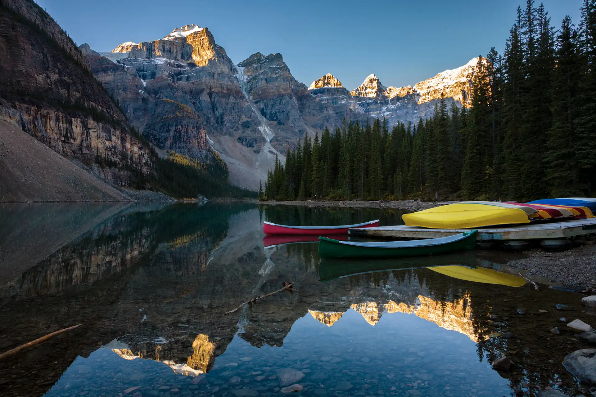 Red canoes at Moraine Lake at sunrise