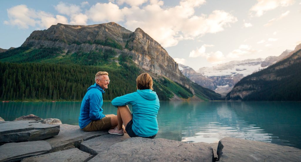 Hiking at Lake Louise with turquoise waters and Victoria Glacier surrounded by Rocky Mountain peaks in Banff